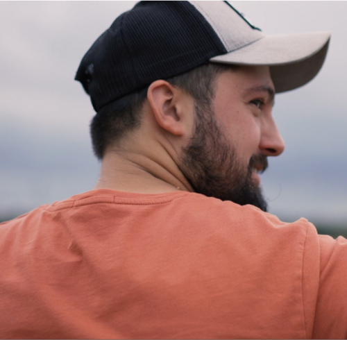 A man with a cap looking to the side in a field